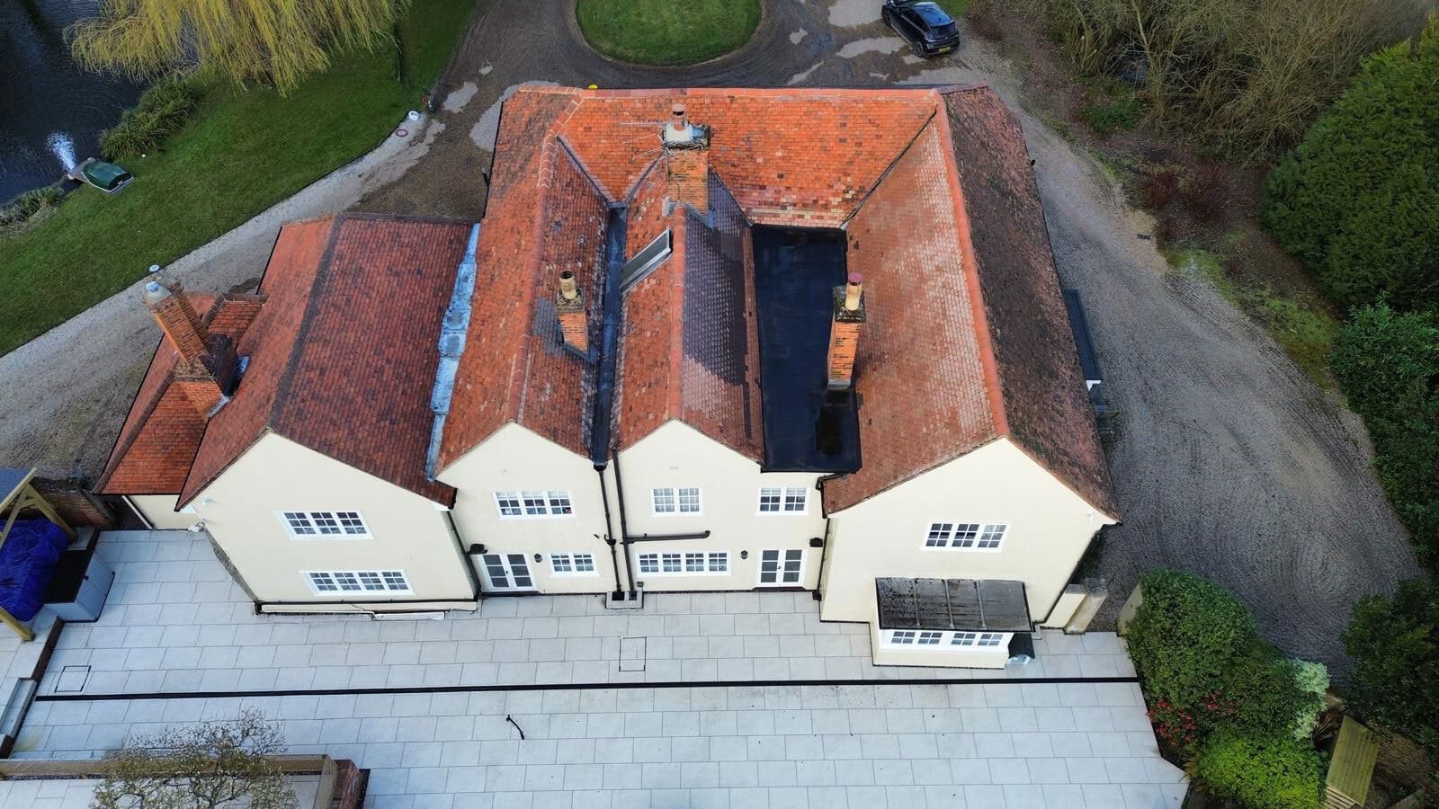 Aerial close-up view of the red-tiled roof of a historic home after roof cleaning in Colchester