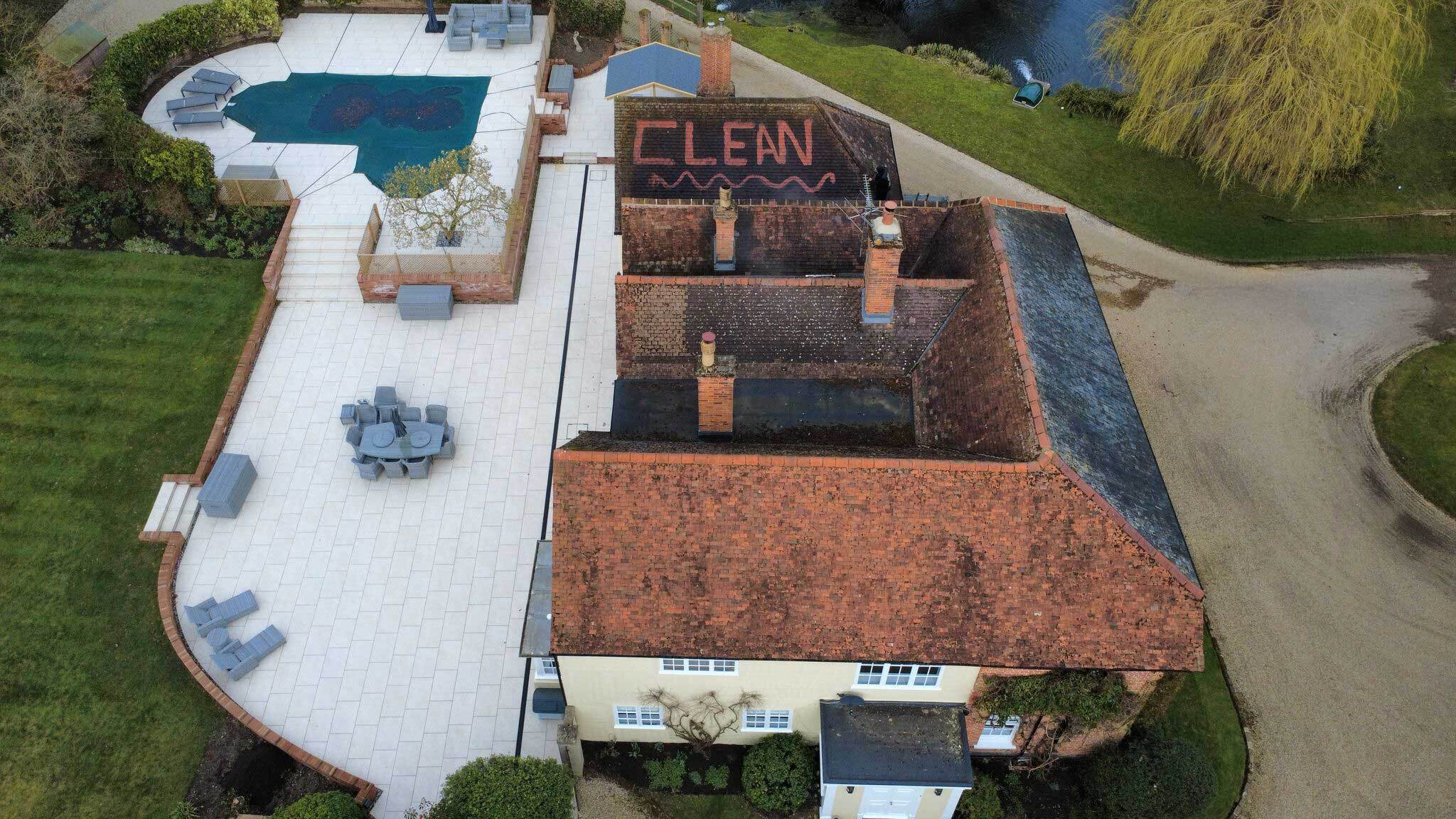 Aerial view of a roof cleaning in Colchester with the word "CLEAN" visibly marked, showcasing the progress of professional roof cleaning