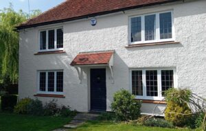 Exterior of large house showing White ProPERLA Wall Coating after exterior wall cleaning