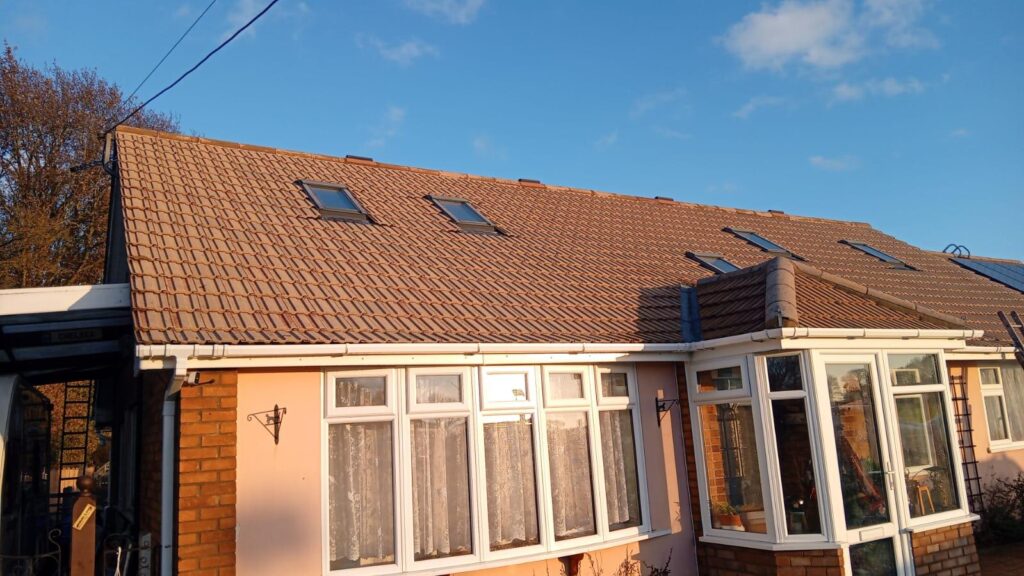 Professional roof tile cleaning project on a residential bungalow with restored red concrete roof tiles