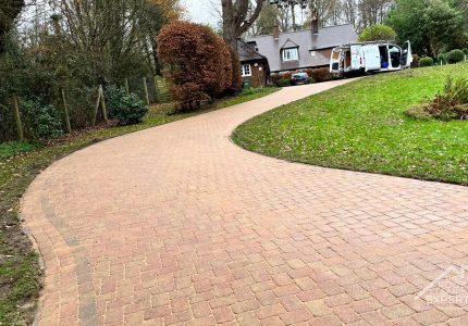 Winding driveway in light brown brick after driveway cleaning by The Roof Cleaning Experts